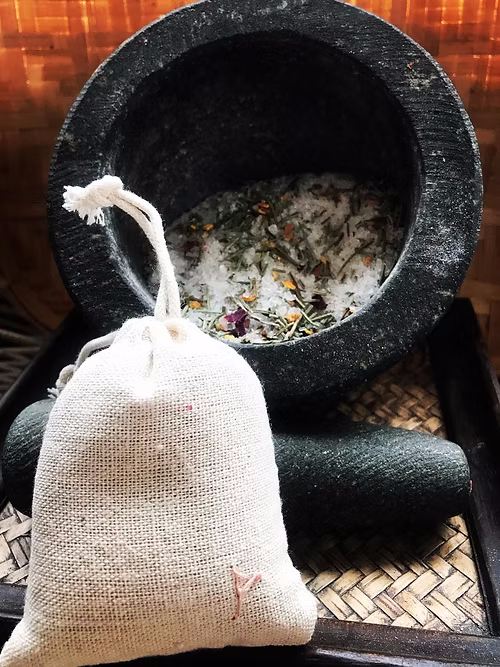 Photos of a fark stone pestle & mortar on a tray with a bag of bath salts