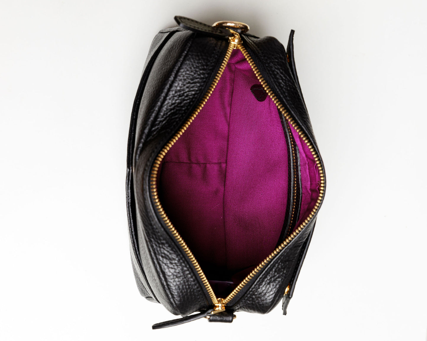 The inside of a black crossbody bag showing the brightly coloured syrah lining and an interior zipped pocket. 