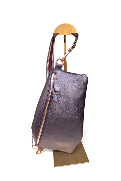 A navy pebbled leather handbag with gold-tone hardware and a straiped woven strap, displayed on a gold-colored metal stand against a white background.