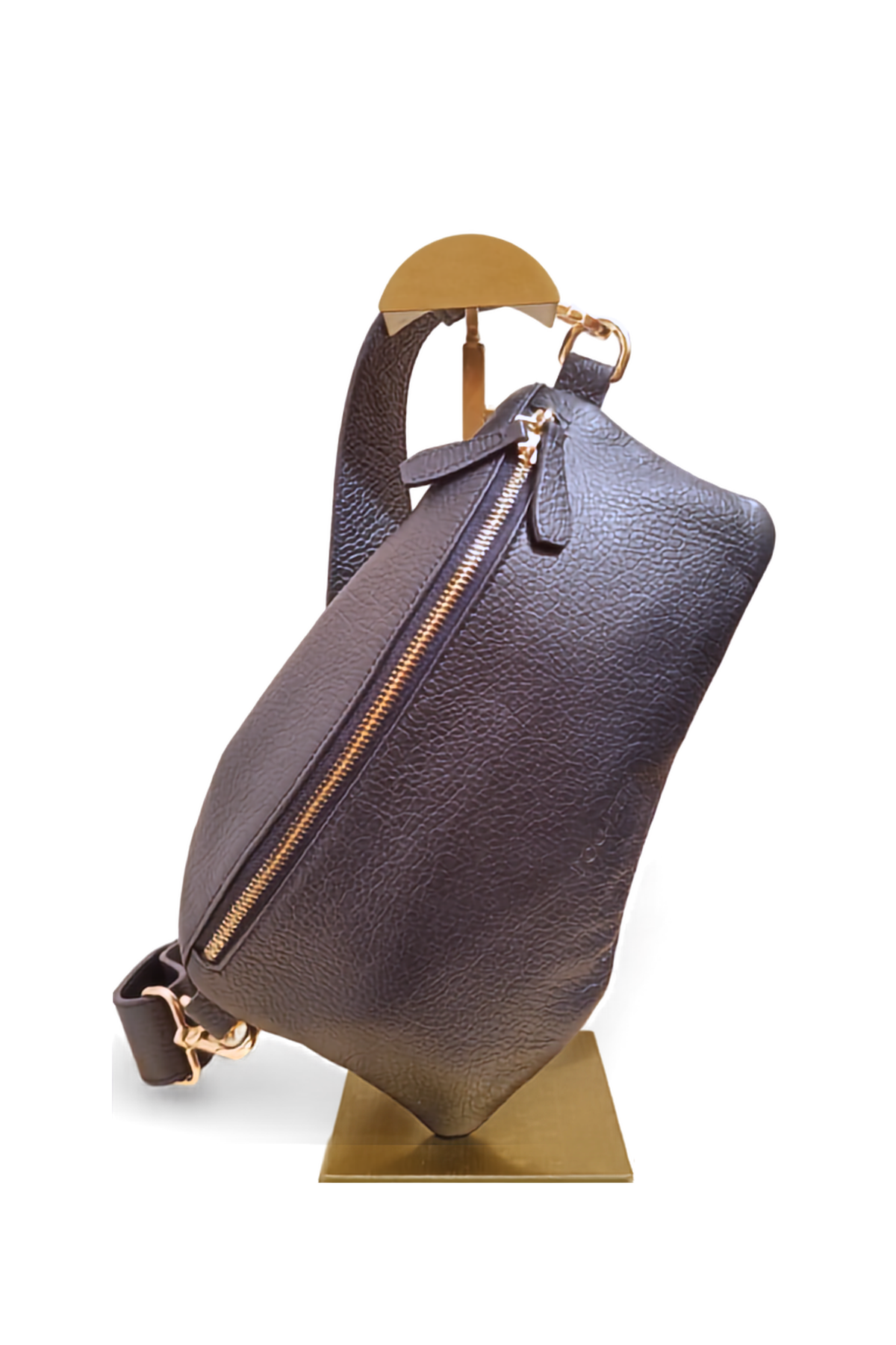 A navy pebbled leather handbag with gold-tone hardware and a wide leather strap, displayed on a gold-colored metal stand against a white background.